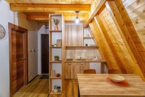 新瓦罗什Zlatarski čardaci的厨房设有木制天花板和木桌