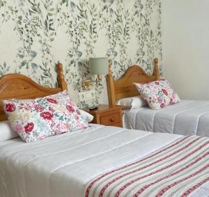 阿特佛阿塔费皇冠酒店的卧室内的两张床,配有花卉壁纸