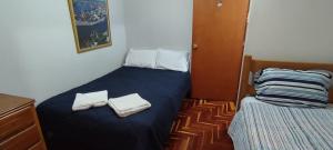利马Apartamento Marco Airport的一间小卧室,配有带毛巾的床