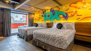 墨西哥城Barrio Downtown Mexico City Hostel的卧室配有两张床,墙上挂着龙