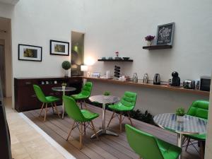 墨西哥城隆巴多套房的一间带绿色桌椅和柜台的餐厅