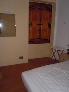 比尔古D-豪斯度假屋的一间卧室设有一张床、一个窗口和一张桌子