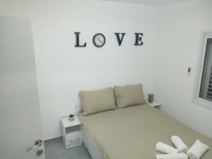 亚实基伦רימון יחידות אירוח Vacation units RIMON的卧室配有一张挂在墙上的“爱”字床