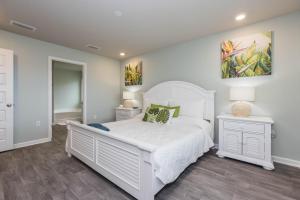 弗利Coastal Bliss的卧室配有白色的床和墙上的绘画作品