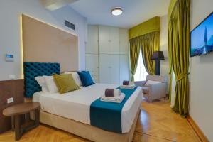 雅典AthINN Residence的一间卧室配有一张大床和一把椅子
