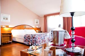 Santa Eugenia de Berga阿鲁米酒店的酒店客房配有一张床和一张带台灯的桌子