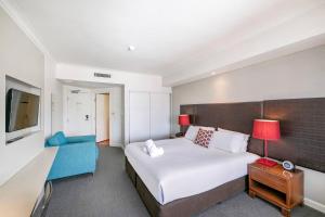 达尔文Modern Harbour Retreat with Sweeping Views Pool的酒店客房,配有一张床和一张蓝色椅子
