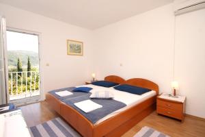 斯拉诺Apartments and rooms by the sea Slano, Dubrovnik - 2682的一间卧室设有一张床和一个大窗户