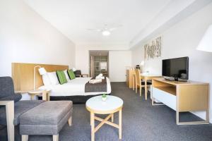 达尔文King Balcony Suite at Resort Style Darwin Stay的酒店客房配有床、沙发和电视。