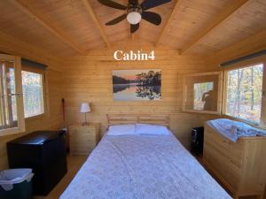 MadawaskaAlgonquin Madawaska Lodge Cottage Glamping Cabins的一间卧室配有一张床和吊扇
