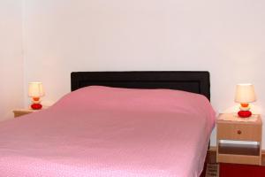 卢卡瓦克Apartment Milna 2461c的一间卧室配有粉红色的床和2个床头柜