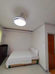 邦劳29 Palm's Panglao Suites的小房间,设有一张床和一盏灯