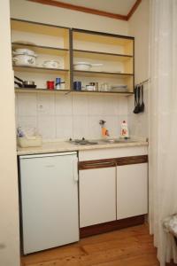 科米扎Apartments and rooms by the sea Komiza, Vis - 2431的厨房配有白色橱柜和白色柜台。