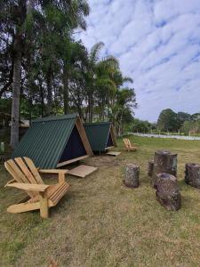 苏扎努FamilyCamp hospedagem perto do Magic City的田野里一组椅子和帐篷