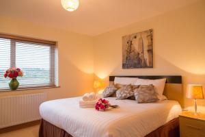 恩尼斯基林Enniskillen Watersedge Apartments的一间卧室配有一张带鲜花的大床