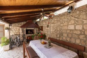 斯拉诺Apartments and rooms by the sea Slano, Dubrovnik - 2687的一间设有桌子和石墙的用餐室
