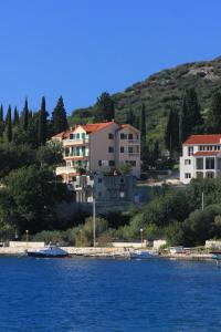 斯拉诺Apartments and rooms by the sea Slano, Dubrovnik - 2681的水体岸边的一群房子