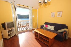 斯拉诺Apartments and rooms by the sea Slano, Dubrovnik - 2681的带沙发、电视和桌子的客厅