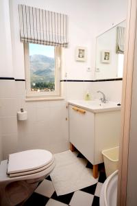 斯拉诺Apartments and rooms by the sea Slano, Dubrovnik - 2681的一间带卫生间、水槽和窗户的浴室
