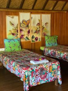 波拉波拉Vaiotaha Lodge的一间设有两张床的房间,墙上涂有蝴蝶