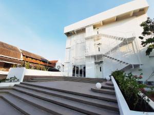 三宝垄Kotta Hotel Semarang的前面有楼梯的白色建筑