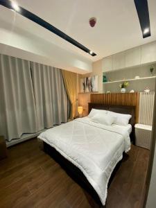 达沃市Aeon Towers Executive Suite 2BR 18th floor的一间卧室配有一张带白色床单的大床