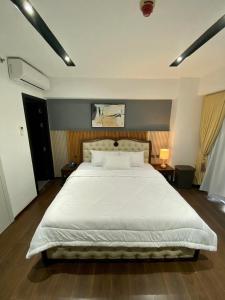 达沃市Aeon Towers Executive Suite 2BR 18th floor的卧室配有一张带白色床单和枕头的大床。