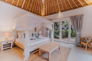 蓝梦岛Villa Escape的卧室配有白色的天蓬床和桌子