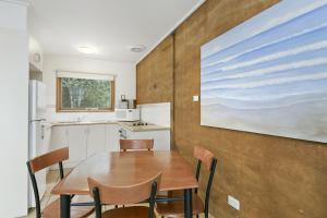 爱丽丝湾分割点别墅的厨房配有桌椅和墙上的绘画作品