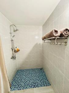 帕皮提J&D Lodge的浴室铺有蓝色瓷砖地板,设有淋浴。