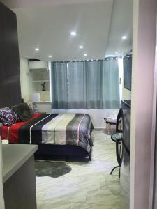 圣胡安Sea breeze vacation lll en Condominio Verde mar的一间卧室配有一张床,并在一间客房内配有电视。