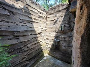 Negara瑟格拉尤瑞普民宿的石墙内带淋浴的浴室