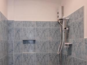 爱妮岛Palmera El Nido Inn的浴室铺有灰色瓷砖,设有淋浴。