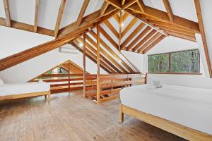 邓斯伯勒Kookaburra Cottage at Woodstone Estate的阁楼卧室设有两张床和木梁。