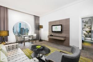 曼谷Holiday Inn Bangkok Silom, an IHG Hotel的带沙发和电视的客厅