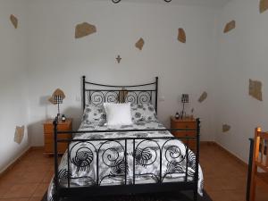 巴尔塞基略Peaceful house set on a vineyard & work friendly的卧室配有一张带白色枕头的黑色床
