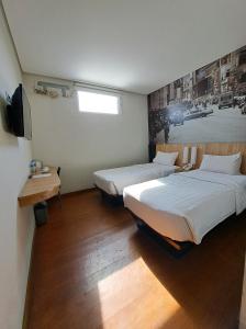 井里汶桑普尔纳锦尔本酒店的一间设有两张床和电视的房间