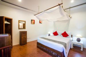 华欣华欣拉萨苏巴度假酒店的卧室配有带红色枕头的白色床