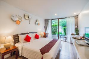 华欣华欣拉萨苏巴度假酒店的一间卧室配有一张床、一张书桌和一个窗户。