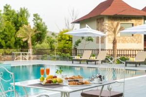 乌代浦Sarasiruham Resort - Private Pool Villa in Udaipur的一张桌子,上面有食物,放在游泳池边