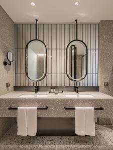 光州Ramada Plaza by Wyndham Chungjang的浴室设有2个水槽和2面镜子