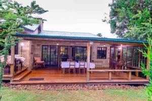 TimauChui Cottage with tennis facing Mt Kenya & near Ngare Ndare的房屋设有1个带桌椅的甲板