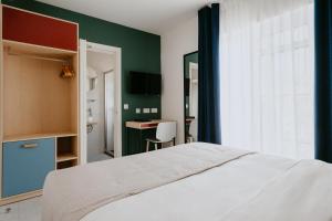 维多利亚Townhouse17 Boutique Bed & Breakfast的卧室配有白色的床和绿色的墙壁