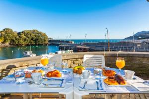 蒙达卡Hotel&Spa El Puerto的一张带食物和橙汁的白色桌子