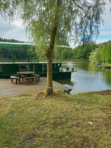 夫洛雷恩le bateau sur lac privé de 2 hectares poissonneux au milieu des bois的野餐桌和河边的船只