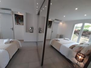 阿格德角VILLA RASOA chambre miroir的白色的客房配有两张床和镜子