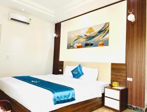 老街市Khách sạn Ngọc Hà的酒店客房设有一张床,墙上挂有绘画作品