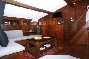 八丹拜The Hidden Escapes Manggis- Stunning Tiny Home set on a Lake with Mountain View, Private Sauna, Pool, Bicycles, BBQ & Butler!的客厅配有沙发和桌子