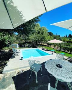 ParambosCasa do Beco B&B Douro - Guest House的一个带桌椅和遮阳伞的游泳池