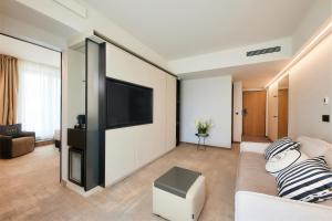 巴拉顿菲赖德LUA Resort - Adults only的客厅配有沙发和墙上的电视